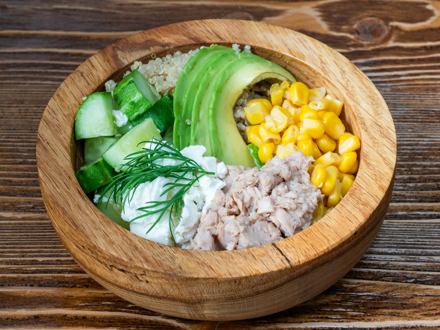 A fresh salad bowl featuring tuna, avocado, quinoa, and veggies. Perfect for a healthy meal.
