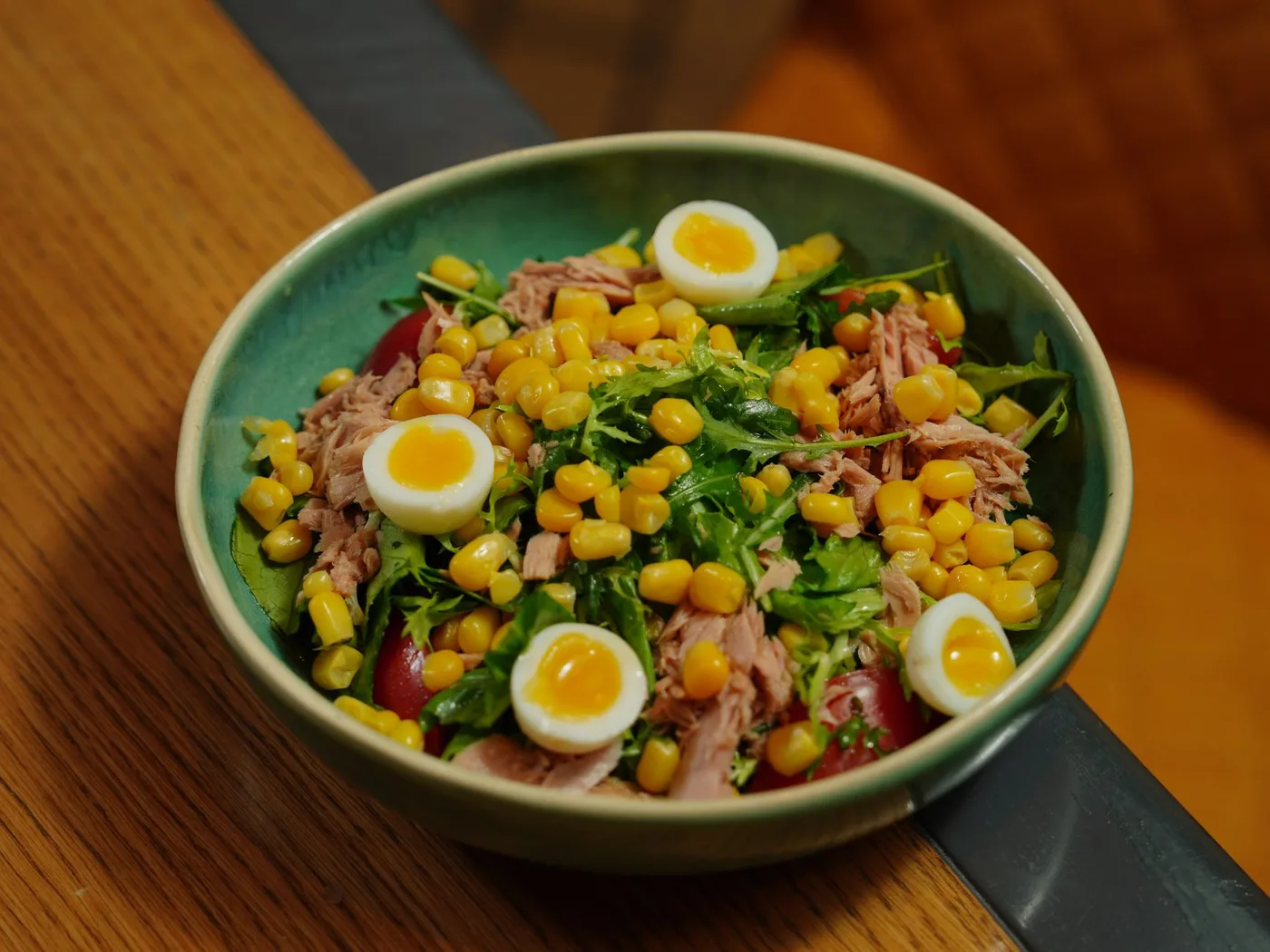 A vibrant bowl of tuna salad with corn and quail eggs for a healthy meal.