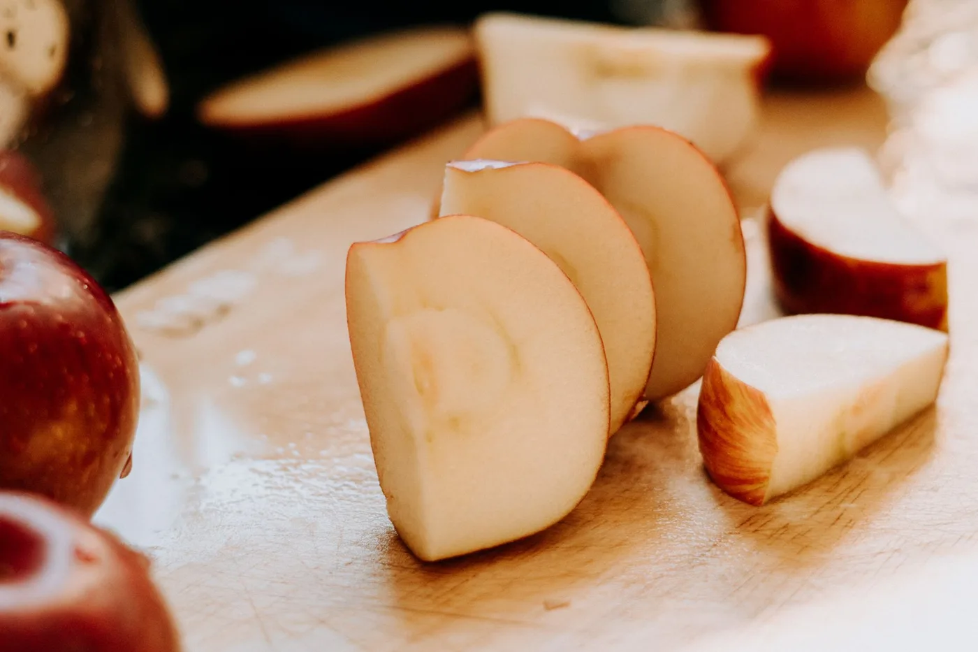 Close-up of fresh apple slices on a wooden cutting board, showcasing healthy snacking.