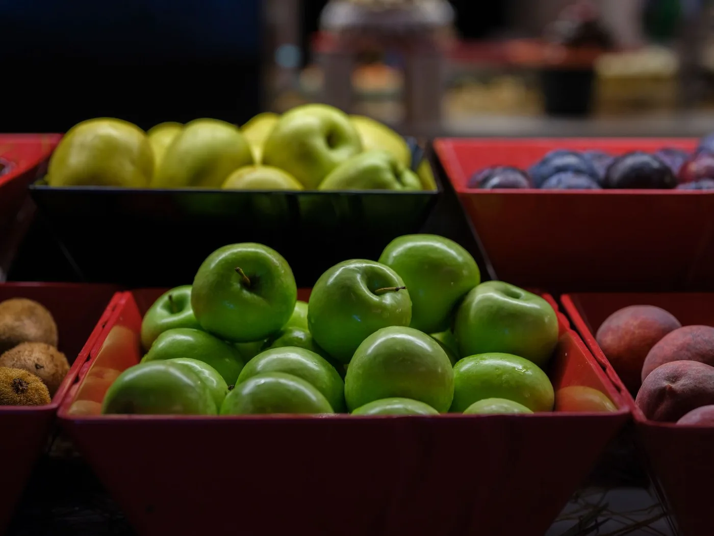 A colorful display of fresh green and yellow apples in baskets, ideal for healthy eating concepts.