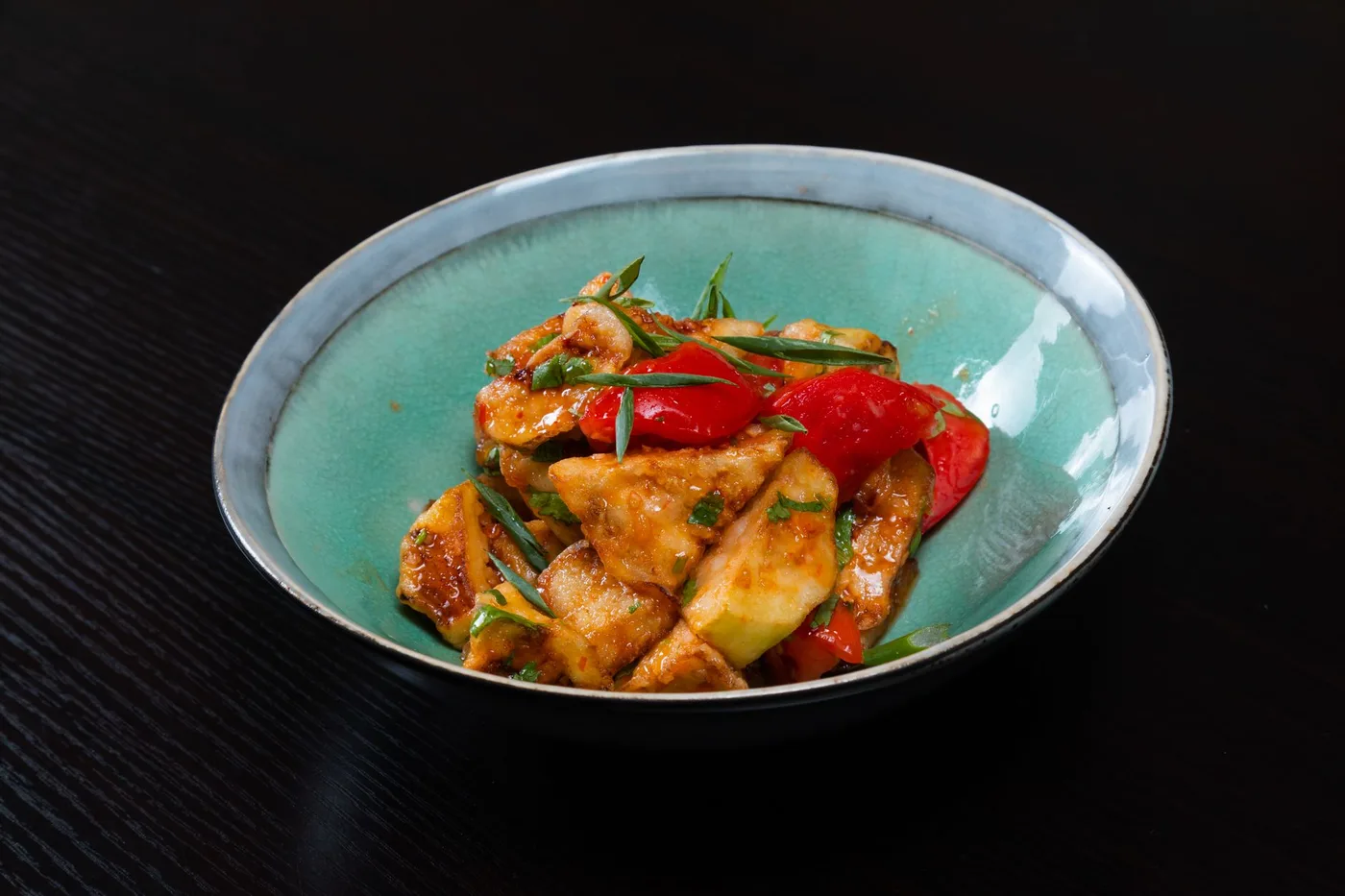 A mouth-watering stir-fried chicken dish with colorful vegetables in a bowl.