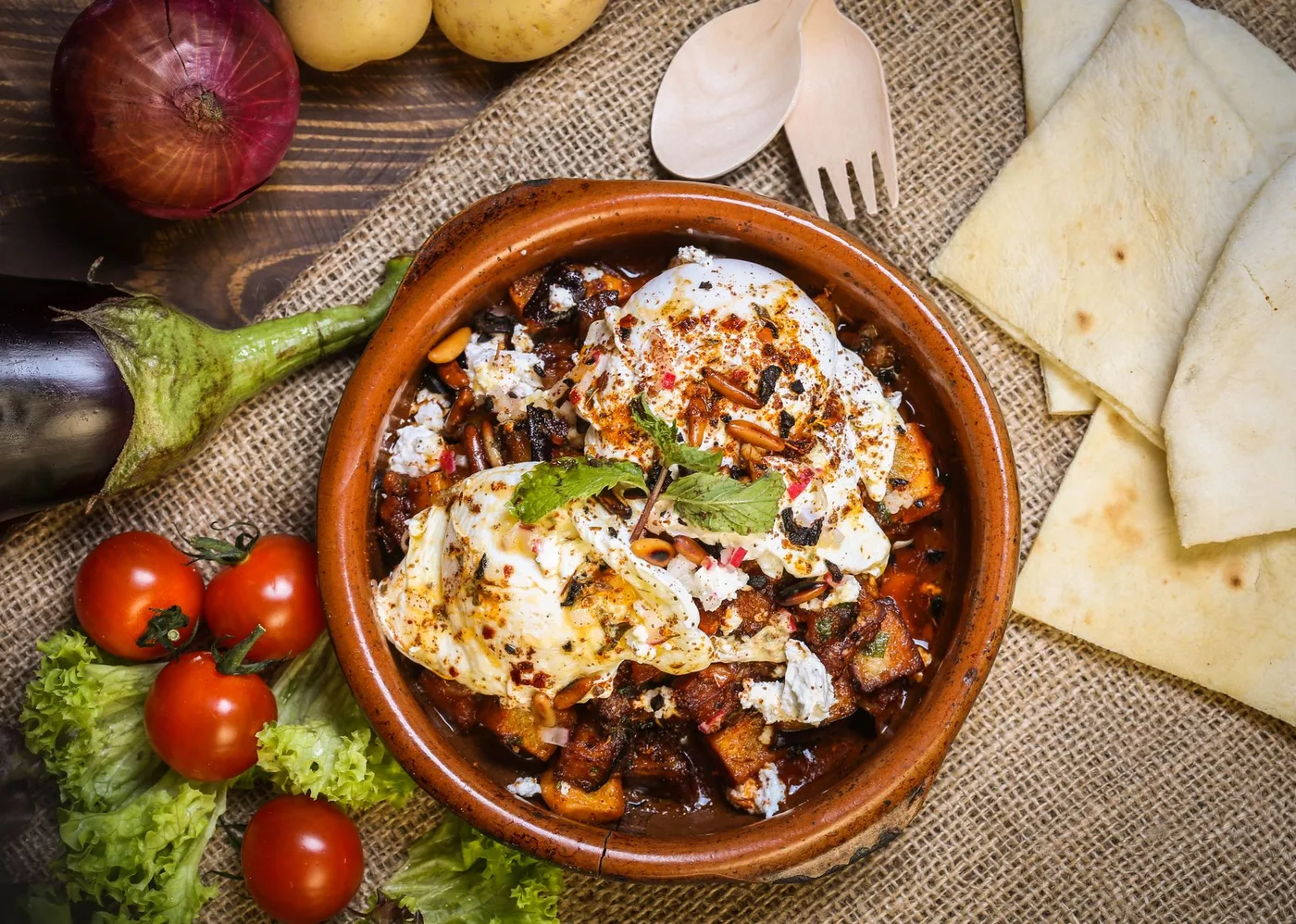 Mouthwatering Middle Eastern meal with fresh tomatoes, eggplant, and herbs.