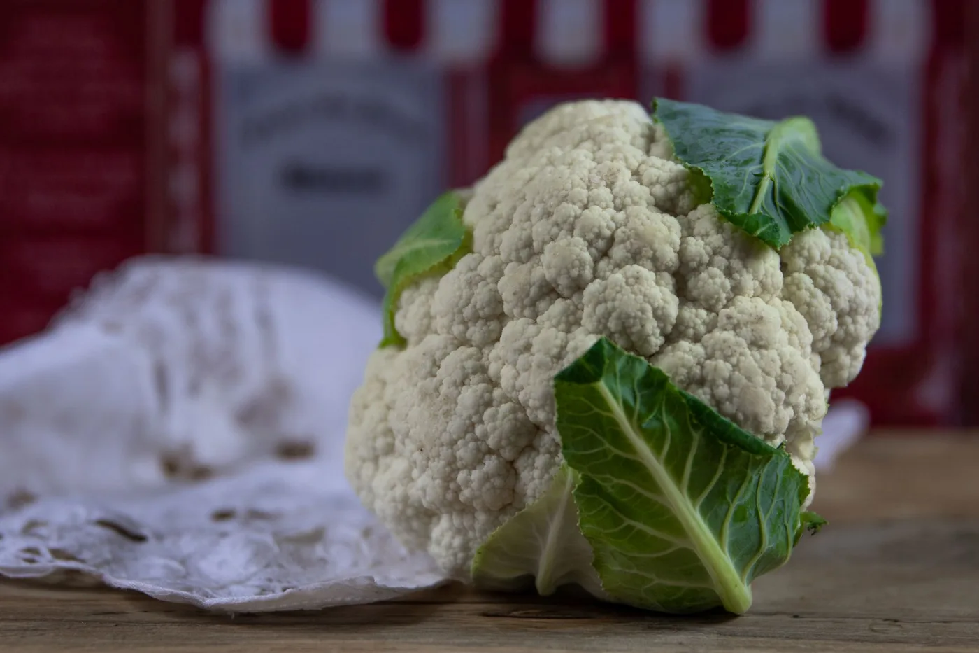 Close-up of a fresh cauliflower head on a rustic table, ideal for healthy eating themes.