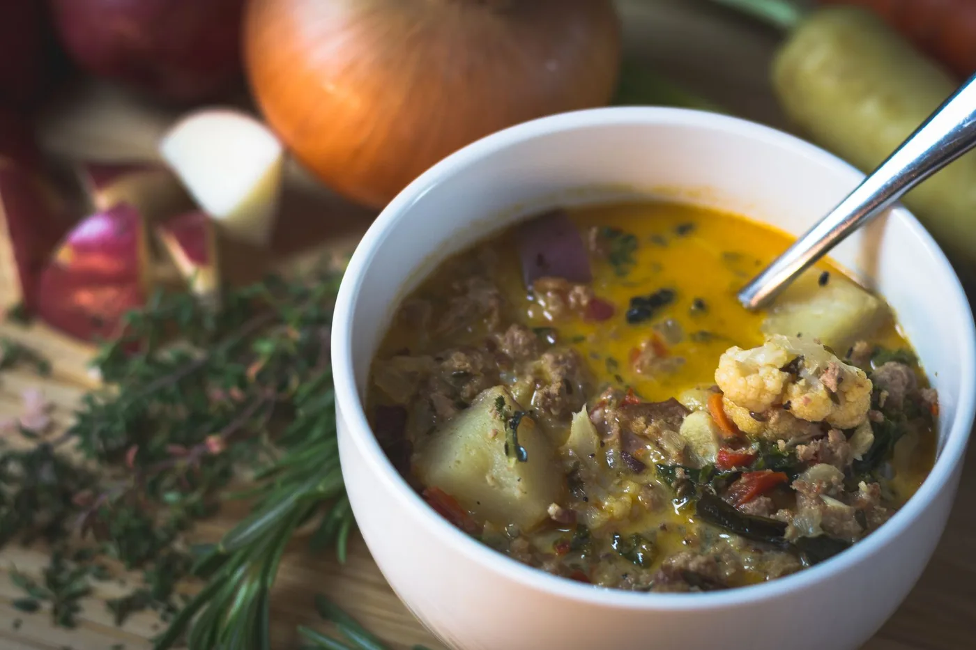 Delicious homemade vegetable soup with fresh ingredients in a white bowl.
