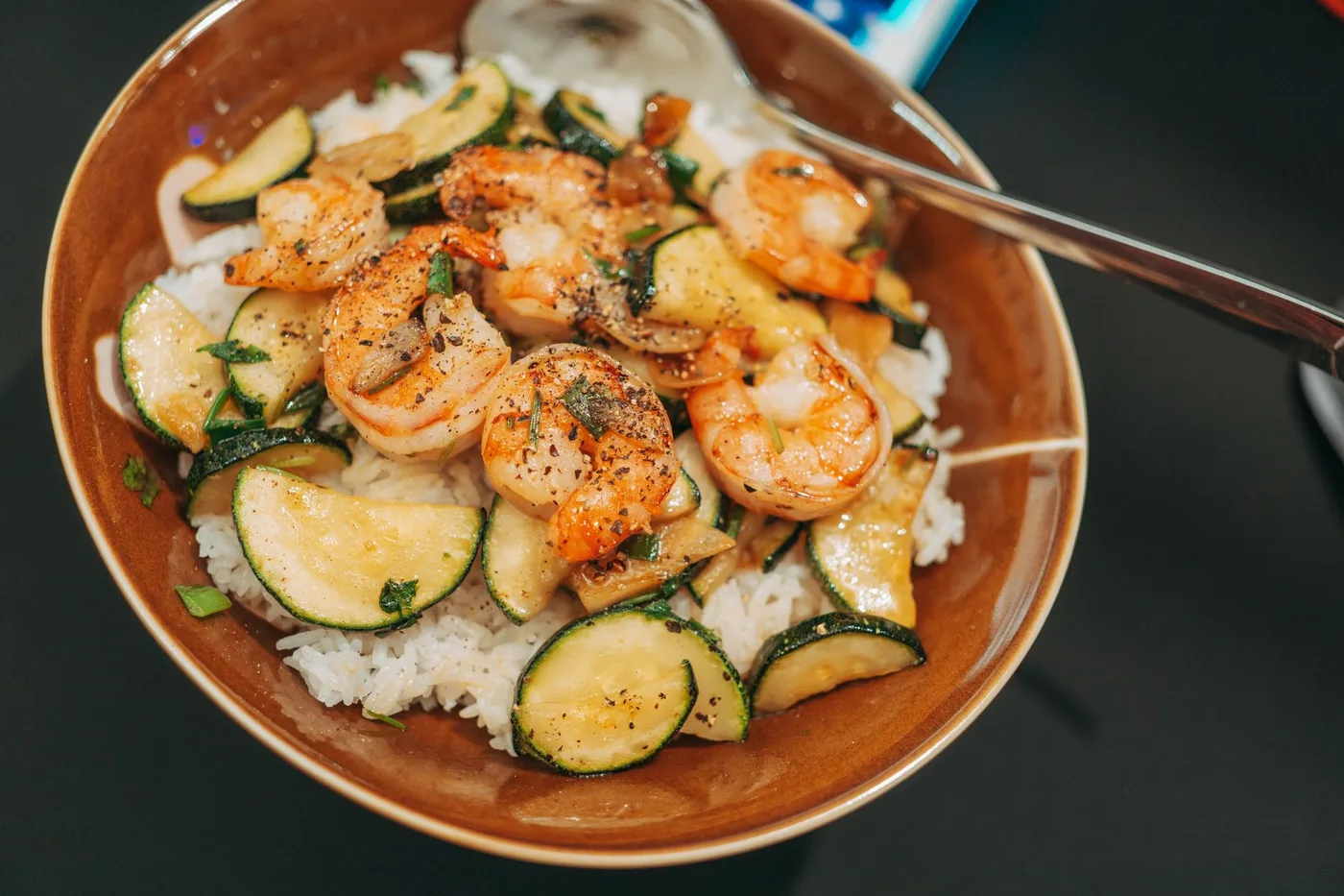 Savory shrimp and zucchini served over fluffy rice, captured in a vibrant food photography style.